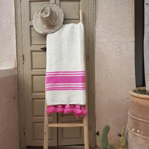white pompom blanket with pink stripes