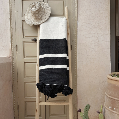 white pompom blanket with black stripes