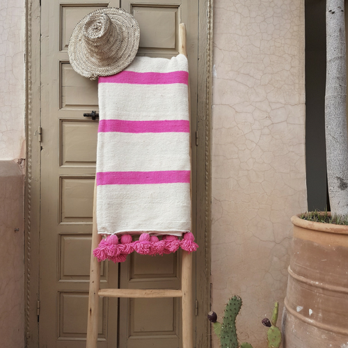 white pompom blanket with pink stripes