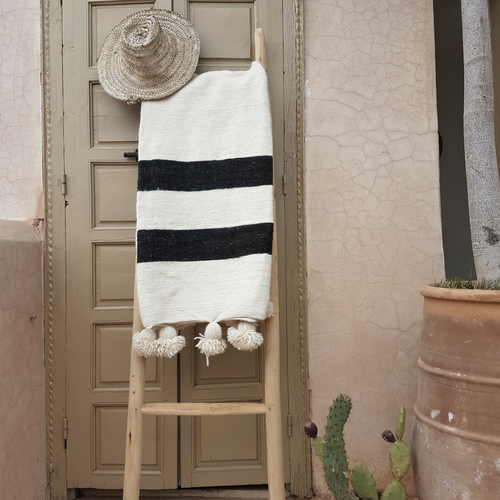 white pompom blanket with black stripes