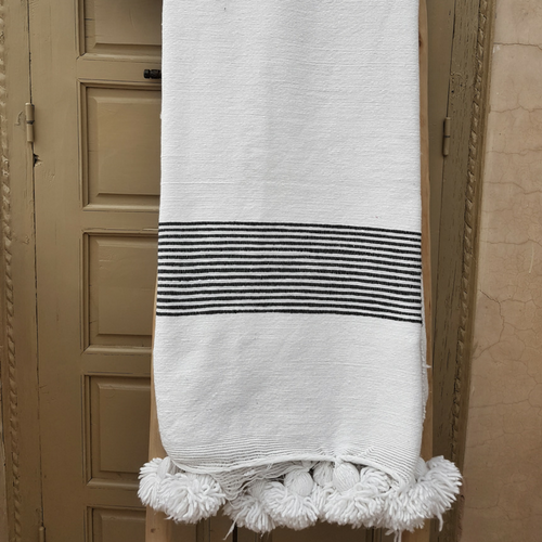 white pompom blanket with black stripes