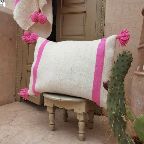 pompom blanket pillow with pink pompoms